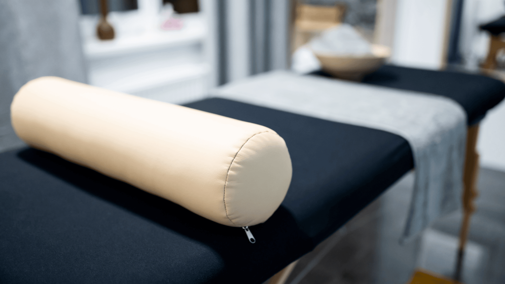 Table de soin avec une serviette et un coussin a l interieur du cabinet de reflexologie a Remouille 44